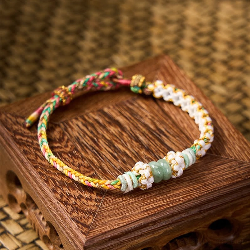 Red luck bracelet showing complete style with braided cord and jade beads