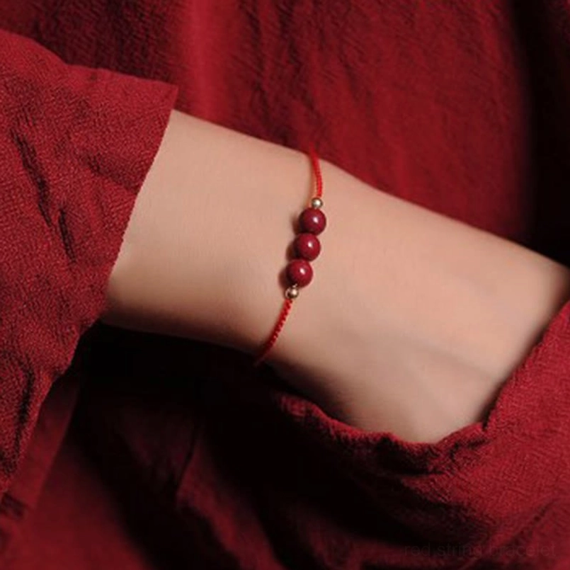 3 cinnabar beads red string bracelet close up worn on human wrist
