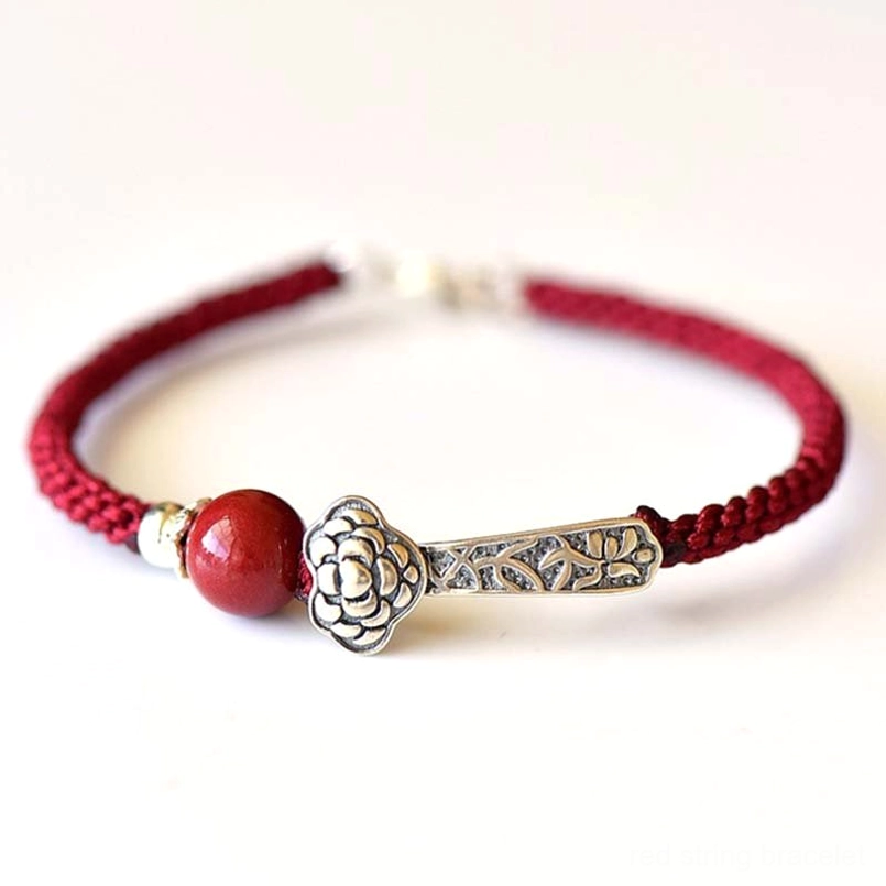 Red cord cinnabar blessing bracelet with engraved silver Ruyi charm front view