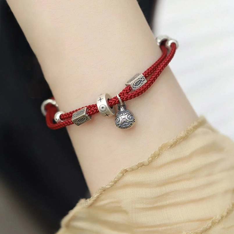 Red woven fortune bracelet with bell charm and engraved silver spacer