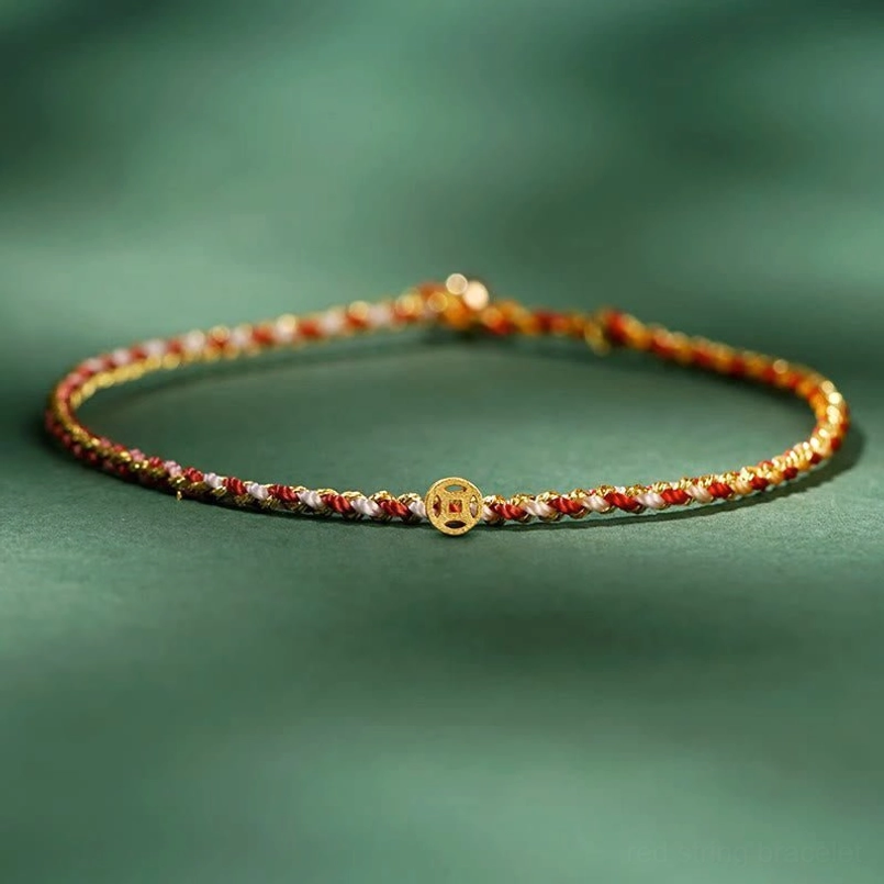 Red and gold toned thin braided lucky coin bracelet with central gold coin pendant