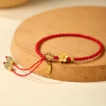 Red braided Hetian jade Fu charm red string bracelet on wooden display tray