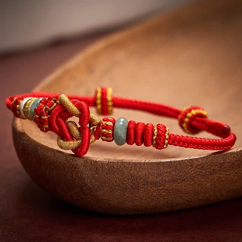 Close-up side view of hand-woven lucky knot red jade bracelet with gold threading
