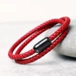 Double-wrap genuine leather red string bracelet with magnetic buckle, side view on stone surface