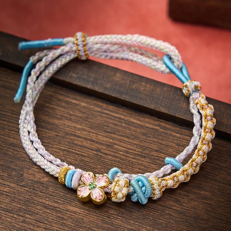 Red peach blossom string bracelet full product shot showing craftsmanship