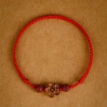 Red peach blossom cinnabar bracelet with braided red string and carved peach wood flower charm