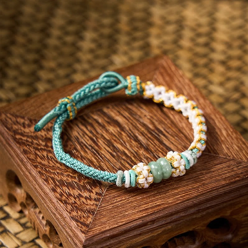 Red handmade luck bracelet with peach blossom details and jade beads