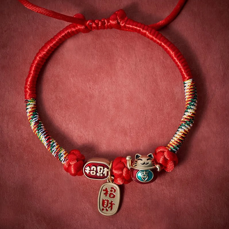 Red handmade pet collar with multicolor woven sections and Fu character charm flat lay