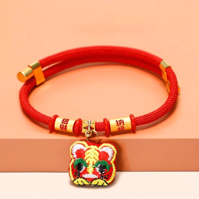 Red pet collar with zhao cai na fu beads and embroidered tiger charm on gradient backdrop