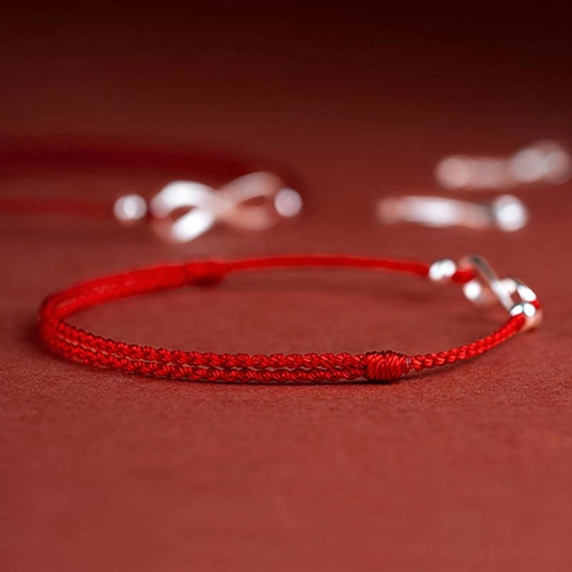 Red cord protective bracelet with silver endless knot clasp detail