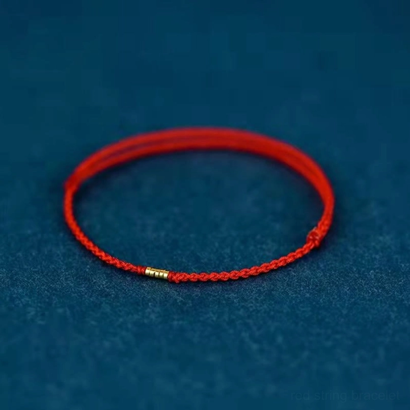 Red string protective bracelet with silver accents worn lifestyle photo