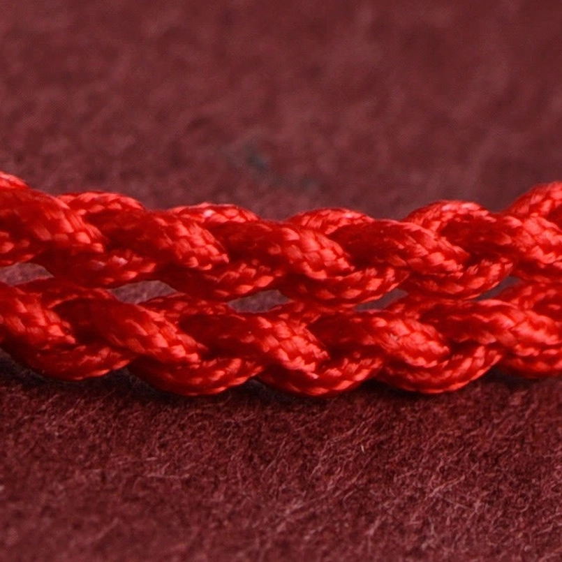 Close-up of braided red rope texture showing twisted two-layer woven design