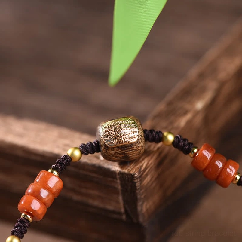 Close-up detail of red sandalwood bracelet showing metal barrel bead, agate tube beads and spacer beads craftsmanship