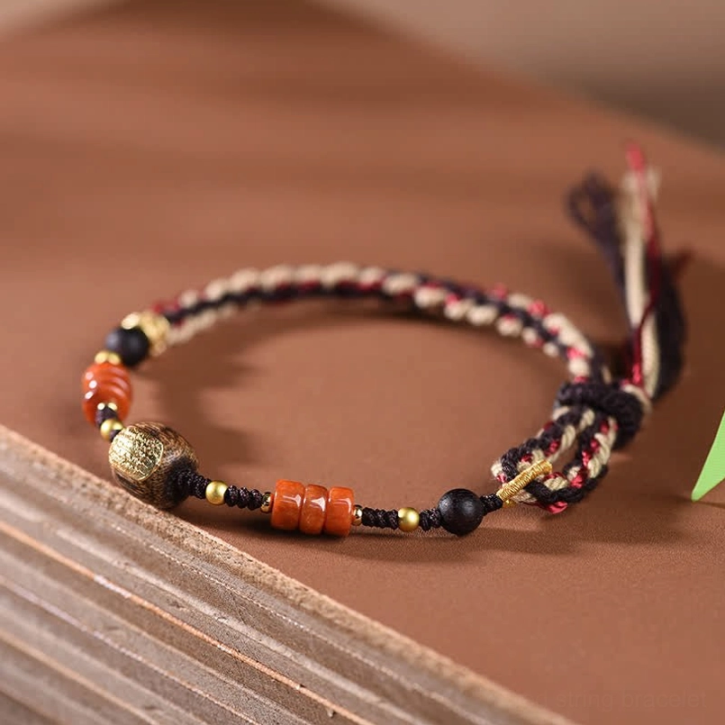 Hand-woven red sandalwood bracelet with twisted braided cord, black gold and agate bead combination on woven mat