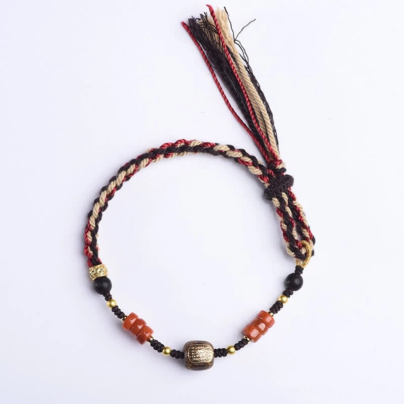 Red sandalwood hand-woven blessing bracelet with full bead and tassel design on clean white background