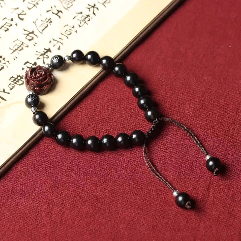 Red sandalwood beaded protection bracelet on vintage calligraphy paper backdrop