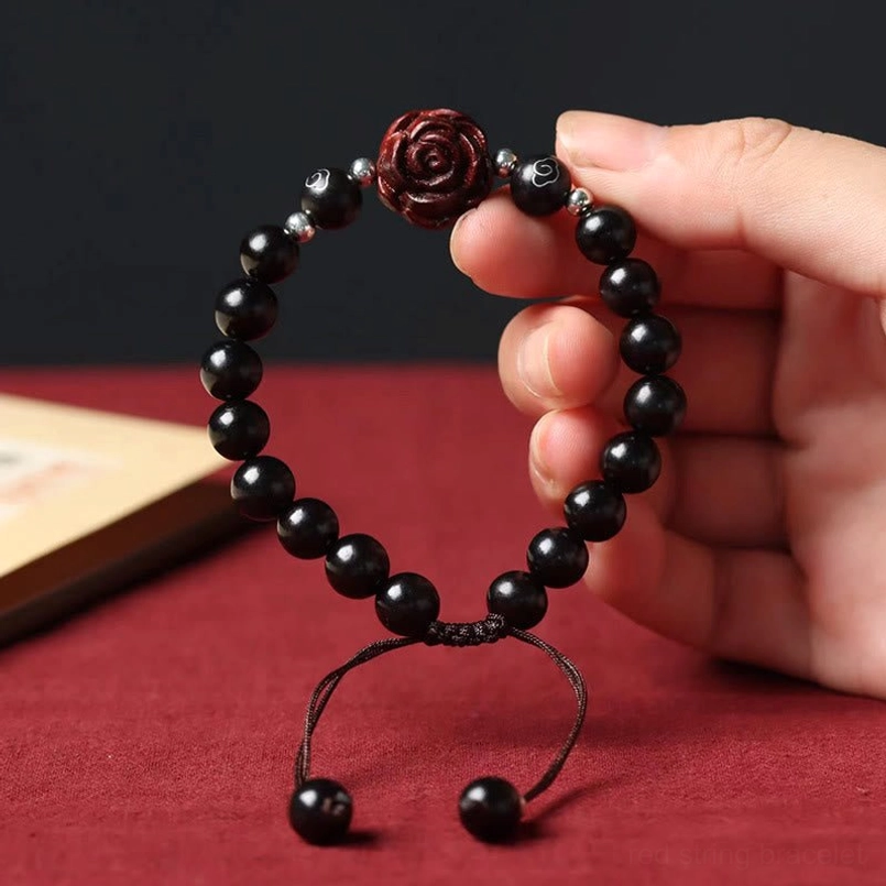 Red sandalwood red string bracelet worn on left wrist adjustable drawstring detail