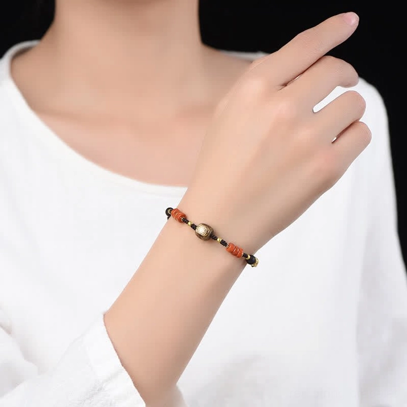 Red sandalwood hand-woven blessing bracelet worn on wrist showing adjustable fit and bead combination in eye-level view