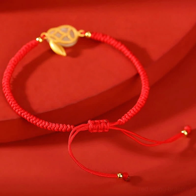 Red string protection bracelet with adjustable sliding knot closure and gold-toned rabbit tail charm