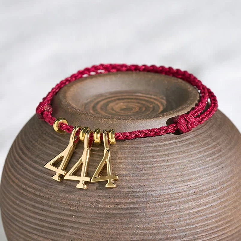 Adjustable red string luck bracelet with angel number pendant - top view detail shot