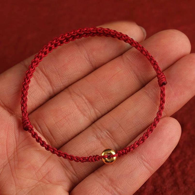 red string anklet with gold peace buckle worn on ankle wellness style