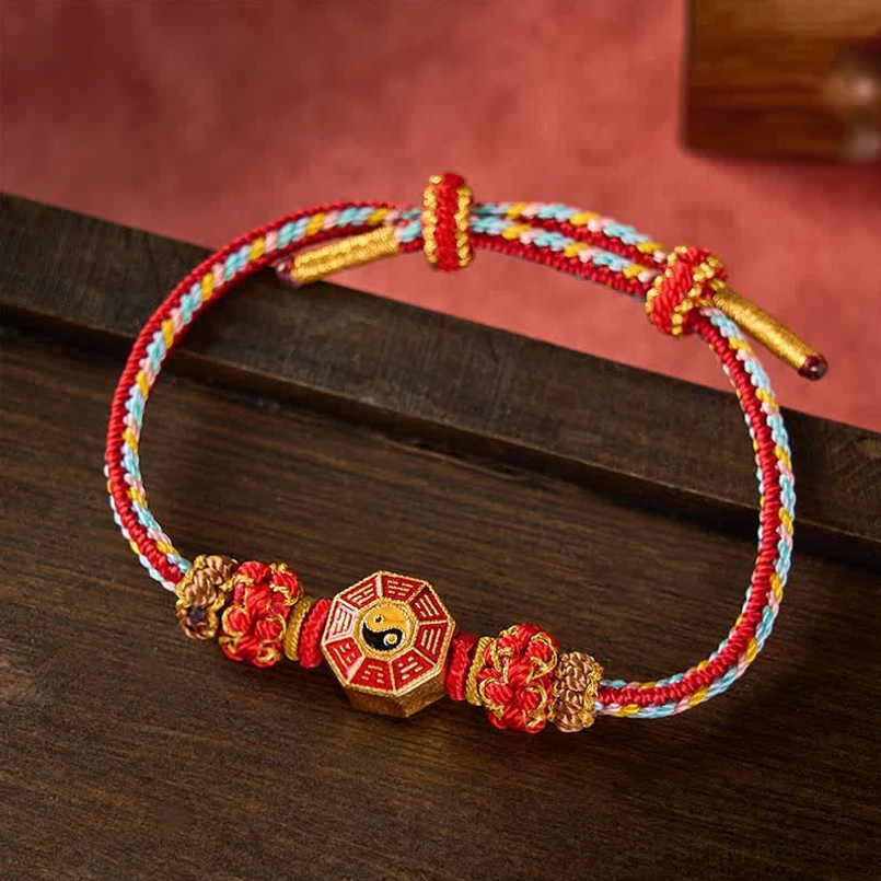 Red string protection bracelet with Bagua charm wooden background lifestyle shot