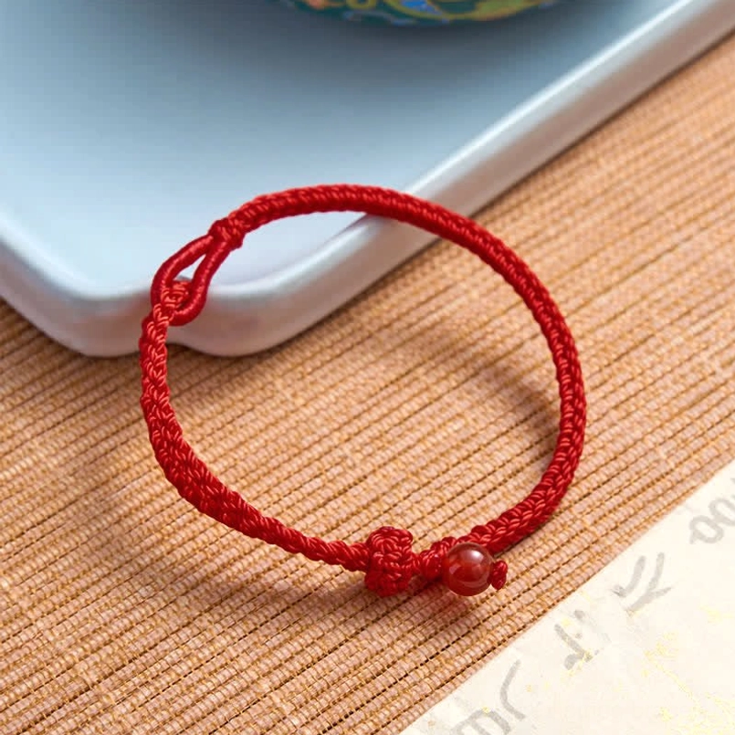 Red string balance bracelet with adjustable sizing on wrist measurement