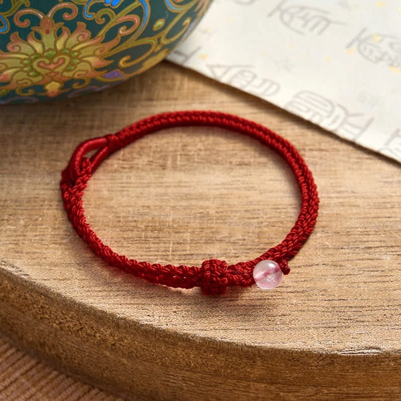Red string balance bracelet gemstone arrangement and cord pattern display