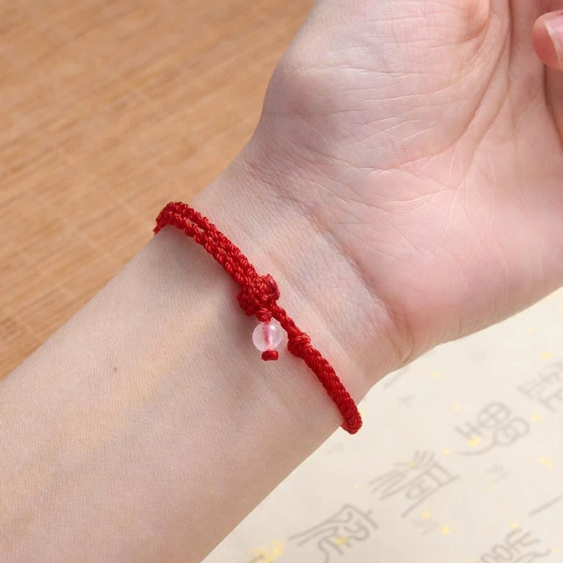 Red string balance bracelet with mixed gemstones and beads close-up view