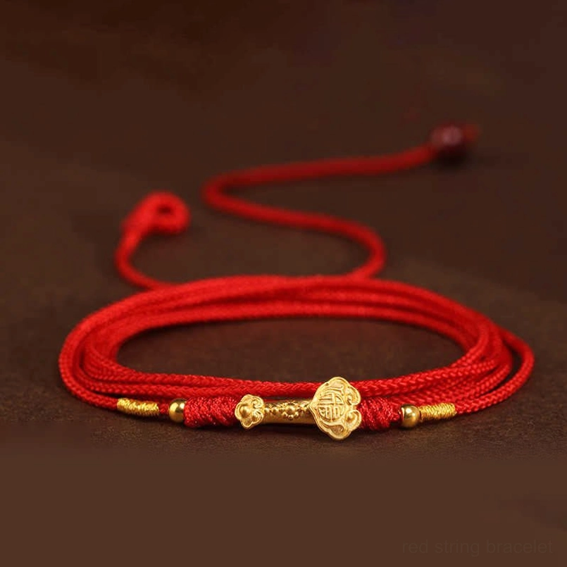 Flat lay top view of adjustable red string belly chain with ruyi-shaped gold charm and bead toggle
