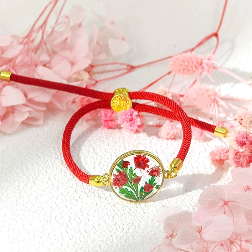 Red cord birth flower bracelet with round resin flower pendant and gold hardware