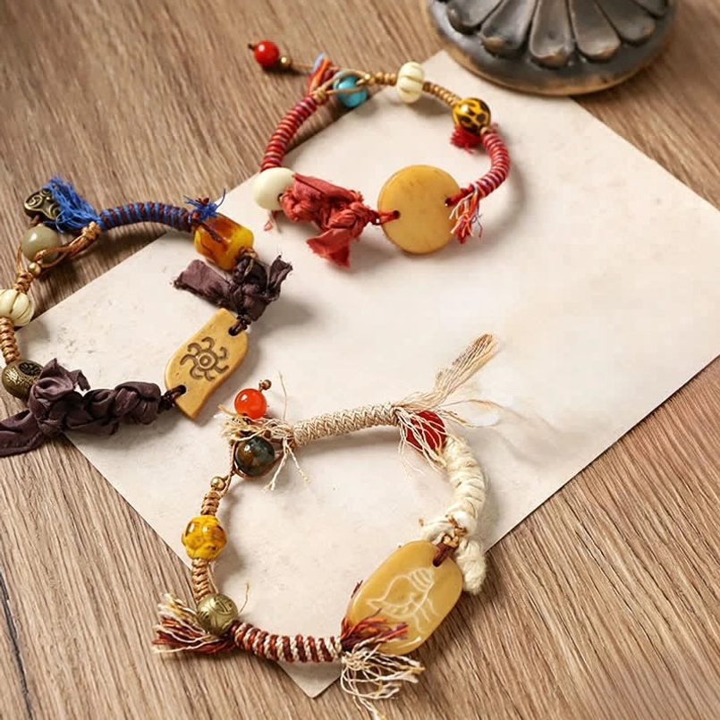 Dark brown and red handcrafted rope bracelets with carved bone Fu pendants