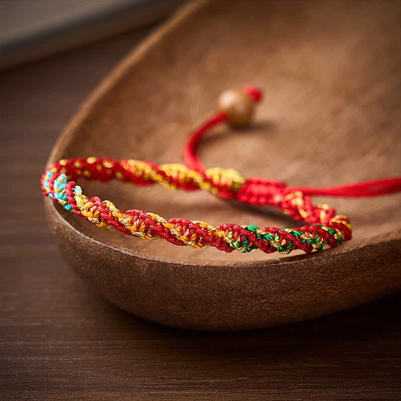 Lucky braided red string bracelet with multicolor cord and wooden bead fastener, lifestyle shot