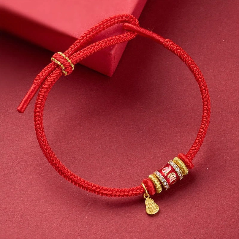 Red string luck bracelet with adjustable knot detail and engraved copper decorative beads