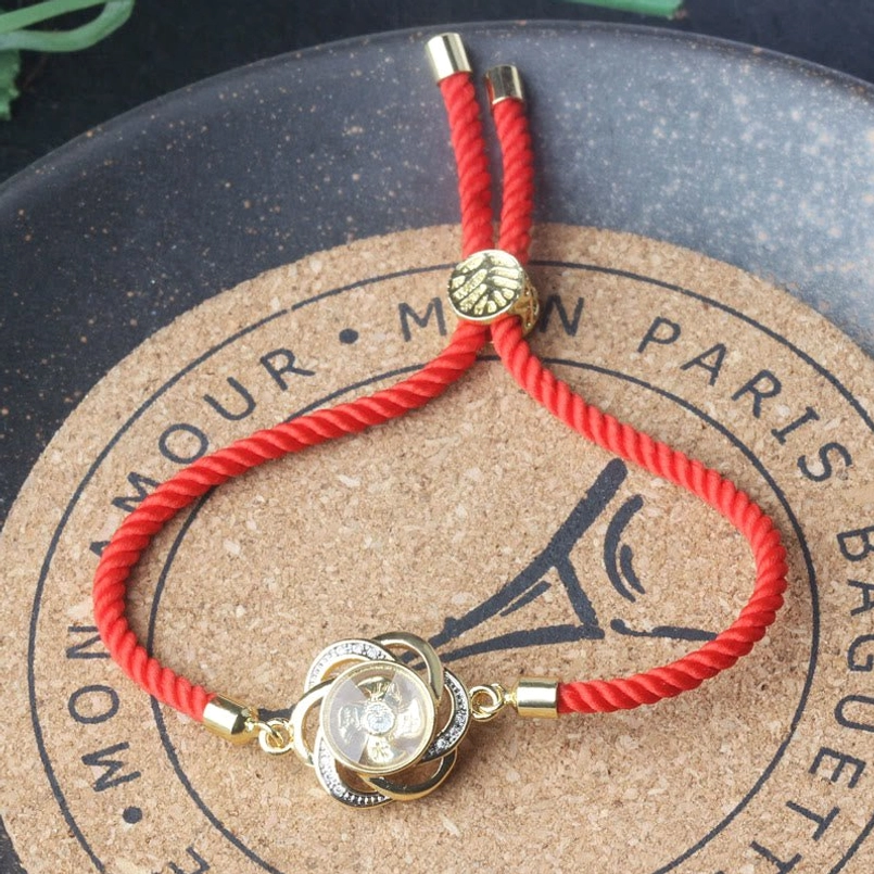 Rotatable plum windmill red string bracelet detail view of sliding knot