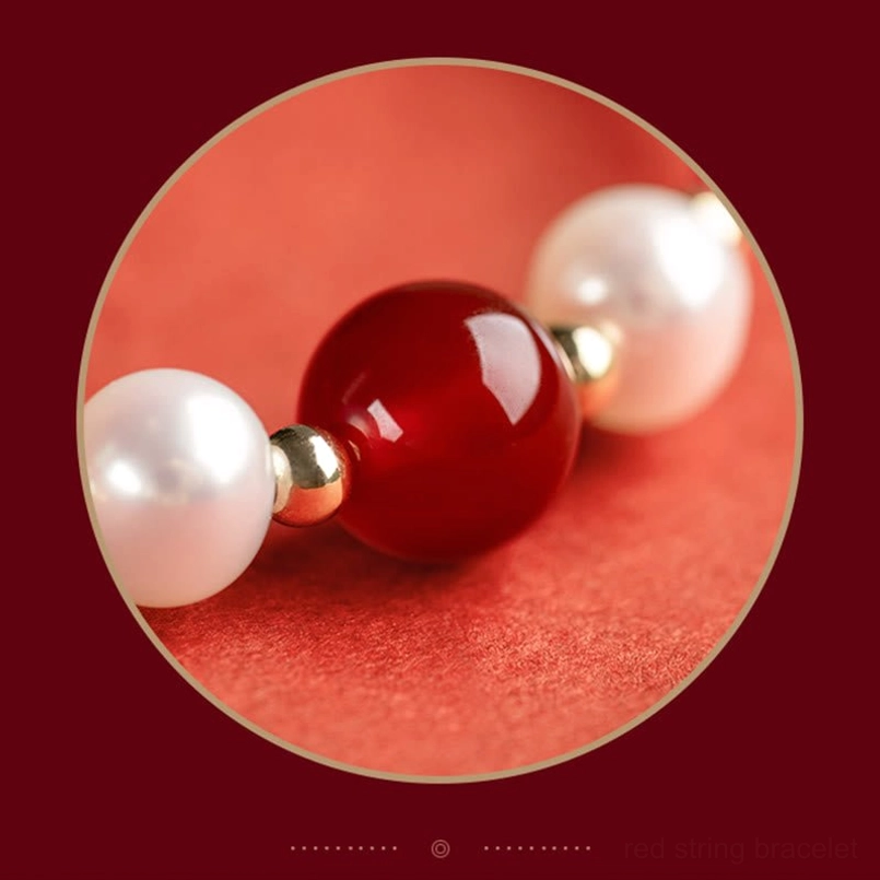 Macro close-up of oversized red agate bead paired with white pearls in dark red circular frame detail
