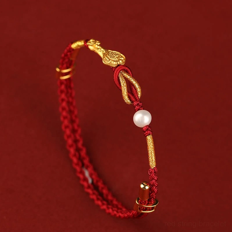 Open red string bracelet displaying Ruyi charm, Fu character, rabbit, and white pearl on red background