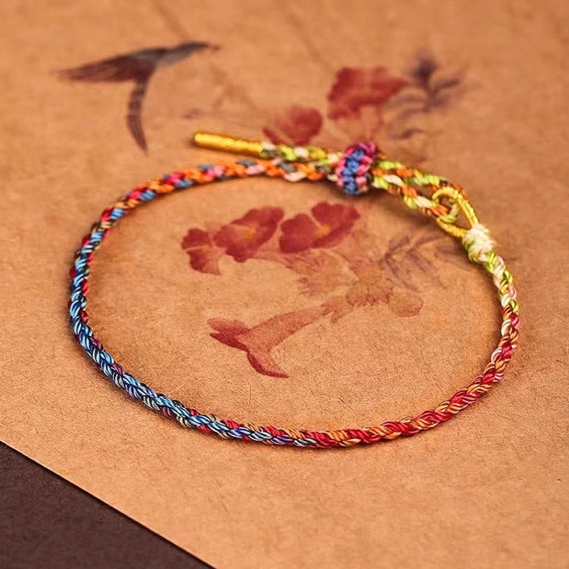 Handcrafted protection bracelet on antique background with warm-tone twisted rope and decorative knot
