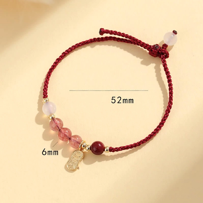 Red string bracelet with engraved Chinese blessing charm close up