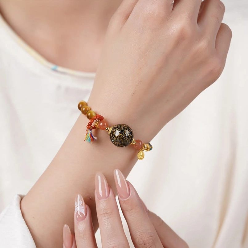 Tibetan lacquer bead tiger eye red string bracelet braided cord texture close up
