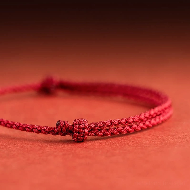 Hand-woven red cord strap with decorative braided knots and adjustable design close-up view