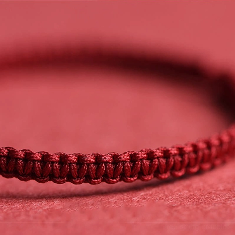 Hand-braided red string bracelet close-up showing tight woven texture
