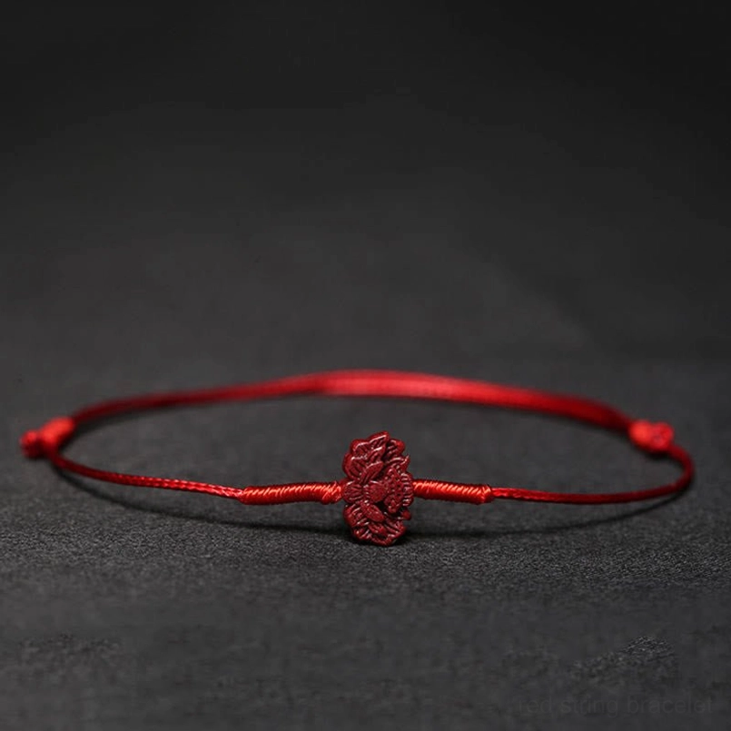 Red string blessing bracelet with multiple charm options display