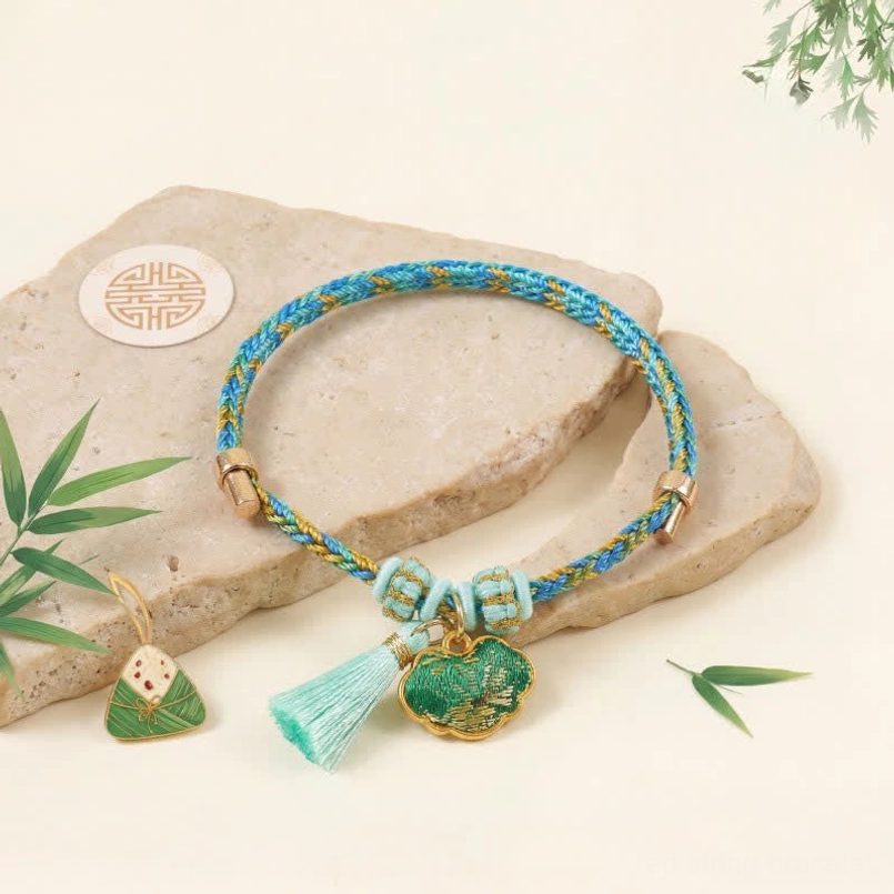 Hand-woven protective bracelet with Chinese Lock Charm enamel pendant blue yellow braided cord turquoise tassel stone background