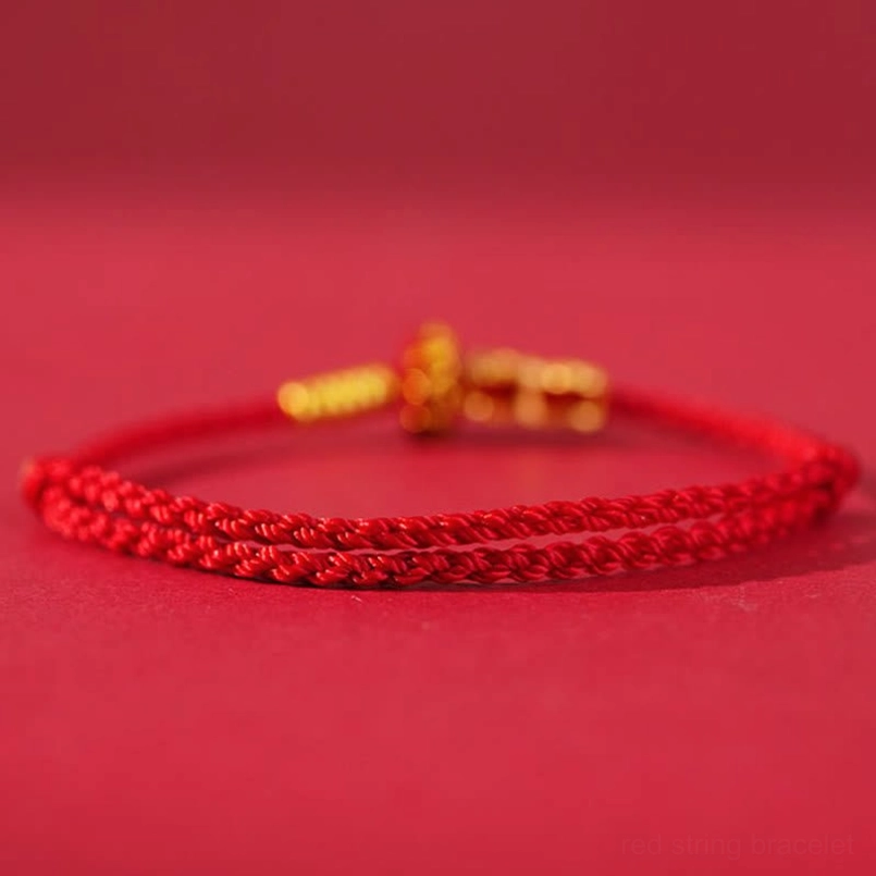 Close-up detail of red woven string texture and copper metal accessories on bracelet