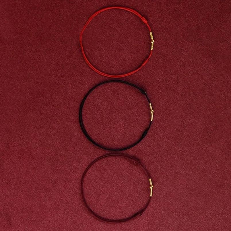 Collection of three handmade red string bracelets in red black and dark red with gold hardware