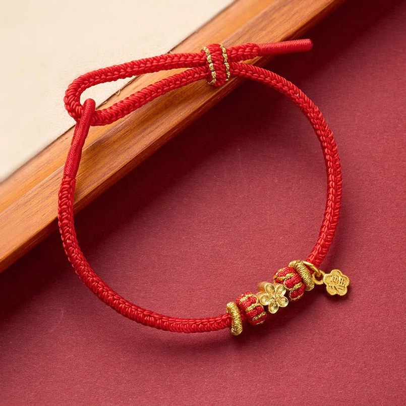 Red string bracelet collection showing various copper bead styles and charm designs
