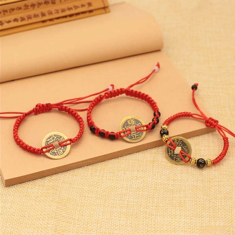 Set of three adjustable copper coin red string bracelets, multiple styles displayed on kraft paper