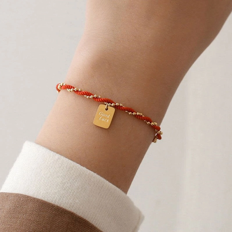 Red string good luck bracelet side profile detail of woven red cord texture