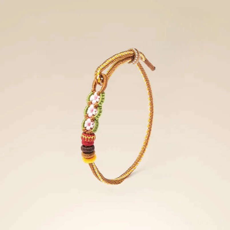 Detailed side view of hand-woven floral red bracelet showing intricate knotting and multi-color beaded ends